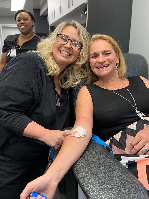 Happy donor giving blood with TBC staff